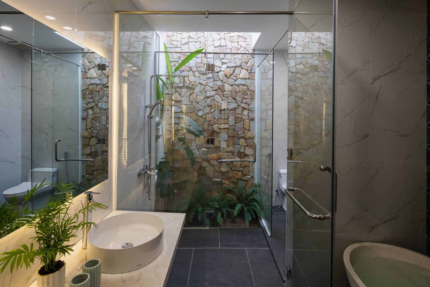 Phòng tắm phong cách mở hiện đại, kết nối với nắng gió, cây xanh.