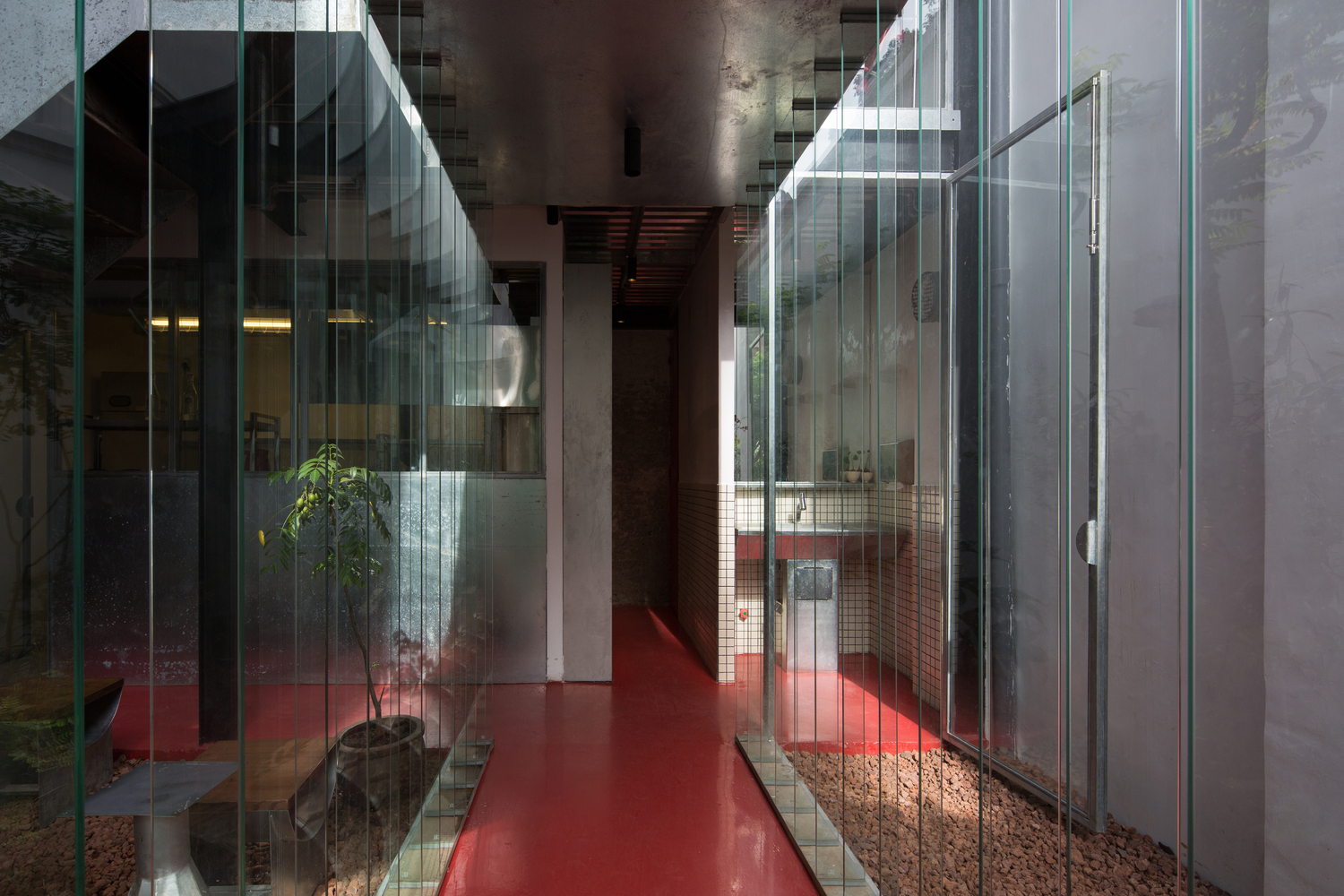 hình ảnh hành lang quán cà phê với sàn lát vật liệu màu đỏ, tường kính trong suốt hai bên
