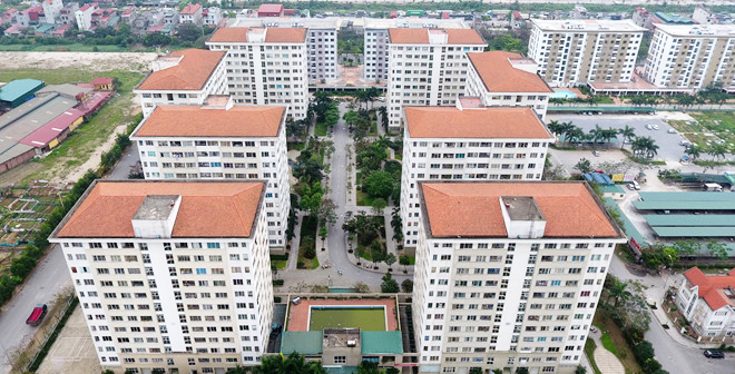 hình ảnh một khu nhà ở xã hội nhìn từ trên cao với nhiều tòa nhà cao tầng mái ngói đỏ, cây xanh, đường nội bộ