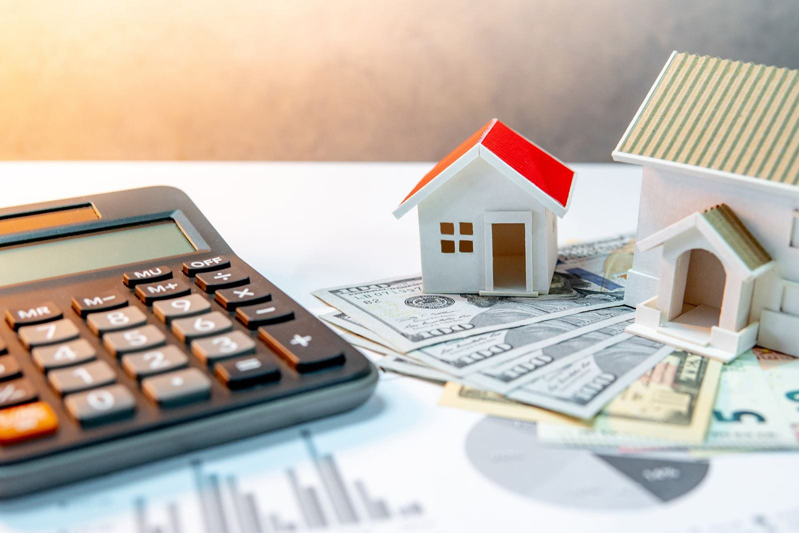hình ảnh mô hình ngôi nhà ngói đỏ, máy tính cầm tay, tiền minh họa cho lãi suất vay mua nhà tháng 3/2021