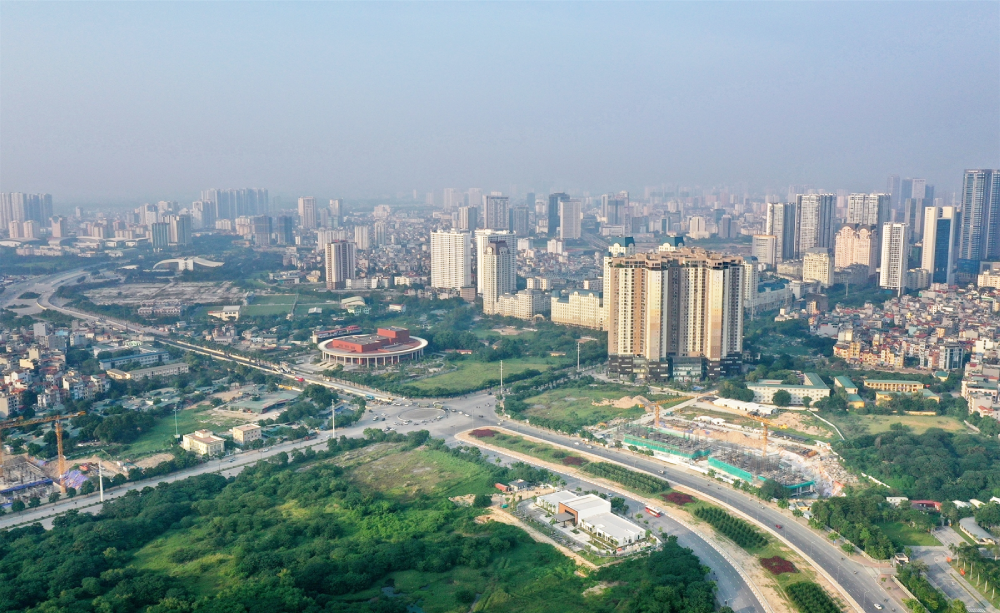 hình ảnh một góc thành phố nhìn từ trên cao với nhiều tòa nhà cao tầng, khu dân cư thấp tầng xen kẽ, cây xanh, khu đất trống làm dự án