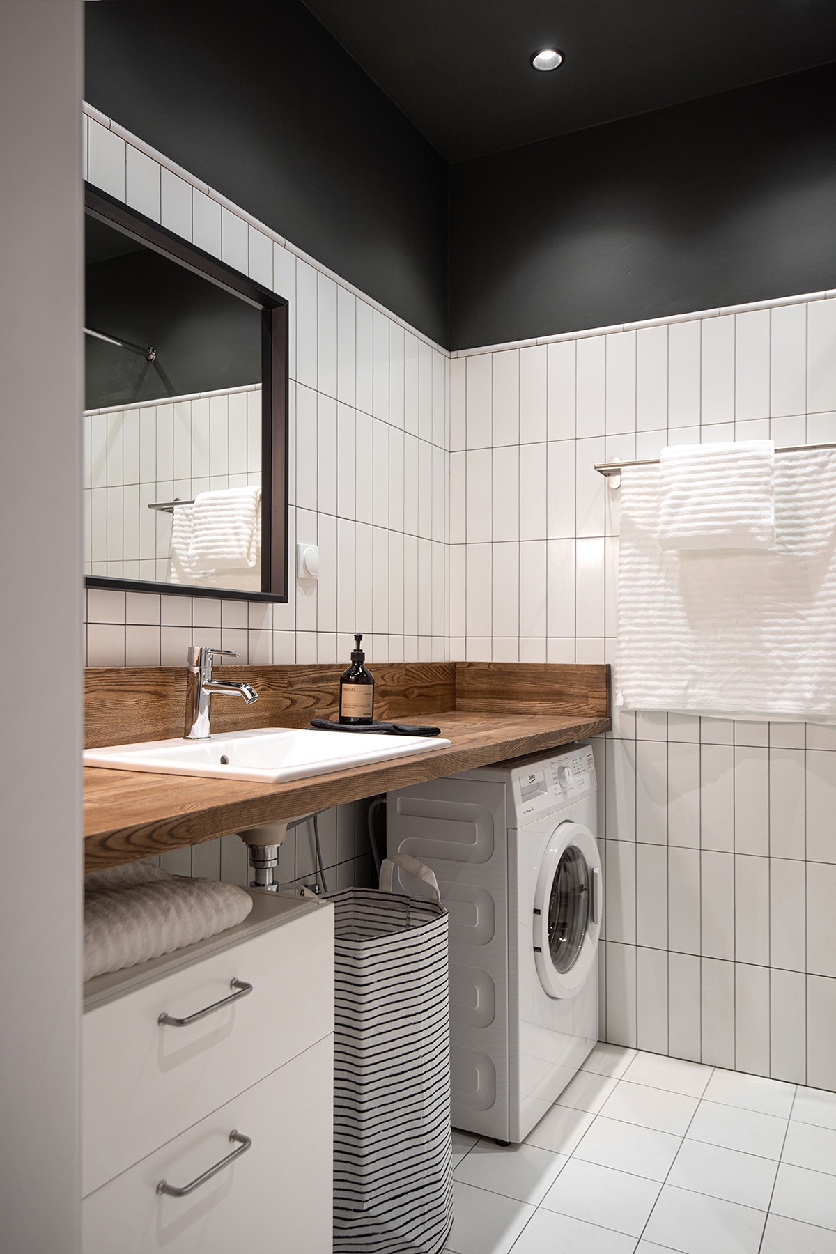 hình ảnh phòng tắm với trần sơn màu đen, tường ốp gạch thẻ màu trắng, bệ gỗ