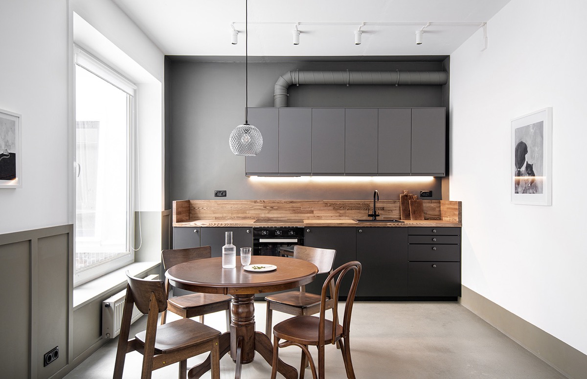 Bộ ba màu sắc nâu gỗ, xám, đen kết hợp trong phòng bếp - ăn giúp gia tăng chiều sâu cho căn hộ 58m2. Cửa sổ kính cao rộng mang đến ánh sáng tự nhiên ngập tràn.