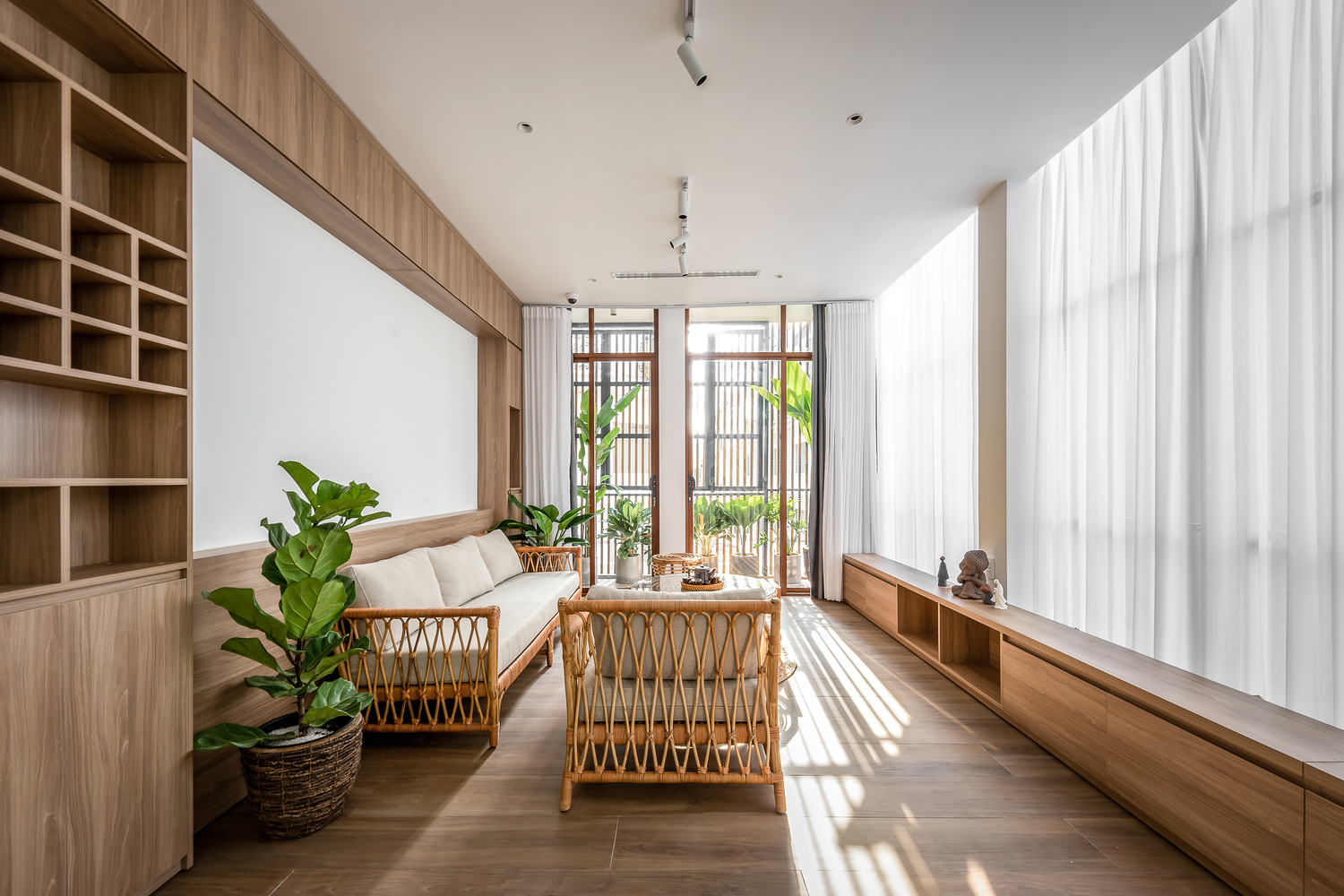 Phòng khách với hệ cửa kính lớn và cây xanh xung quanh, giúp giải phóng tầm nhìn, tạo sự thoải mái khi sống trong không gian nhỏ.