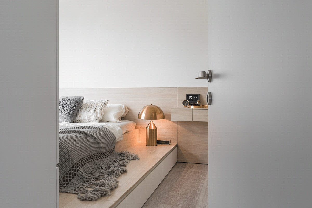 Sắc trắng - xám - nâu gỗ kết hợp ăn ý trong phòng ngủ nhỏ xinh. Đèn ngủ chất liệu đồng sáng bóng như một điểm nhấn sang trọng.