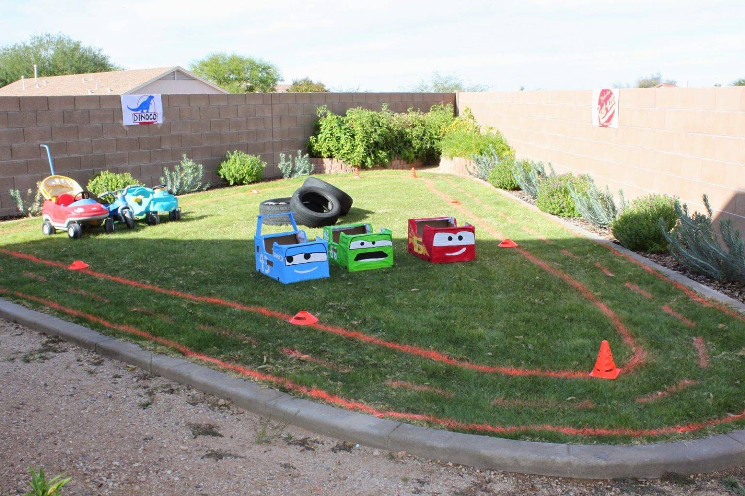 hình ảnh sân cỏ sau nhà với các đường kẻ màu, ô tô đồ chơi