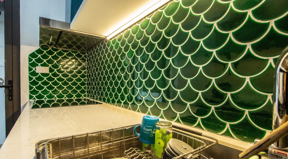 Vật liệu ốp tường chắn bếp màu xanh ngọc, họa tiết vảy cá ấn tượng, vừa sạch vừa sang.