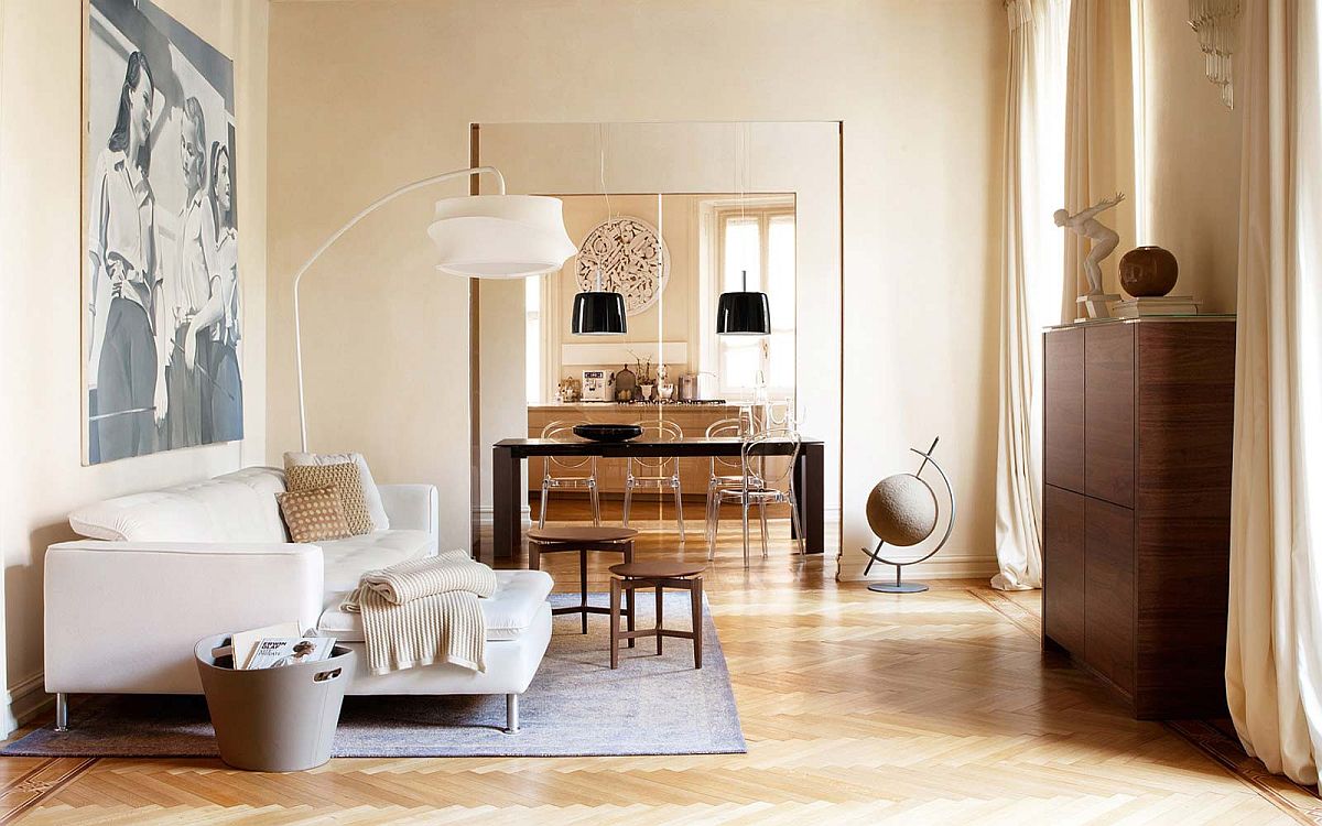 Ghế sofa và đèn sàn màu trắng tinh khôi nổi bật trên nền nâu gỗ sáng mang đến vẻ ấm áp, sang trọng cho không gian phòng khách.