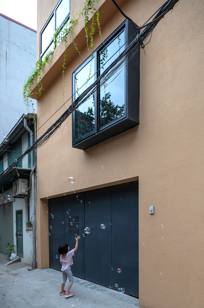 hình ảnh bé gái chơi thổi bóng bóng ở mặt tiền ngôi nhà ở Trâu Qùy