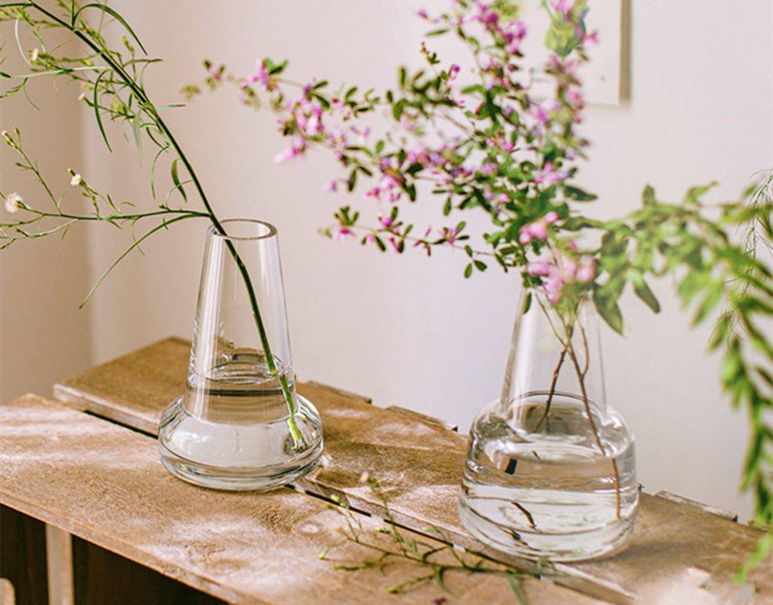 hình ảnh cận cảnh 2 bình hoa thủy tinh đặt trên bàn gỗ phòng bếp