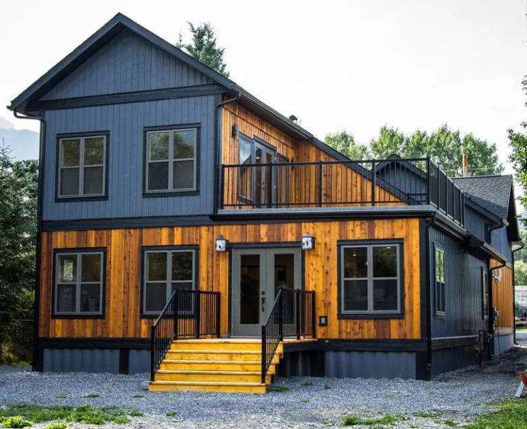 Một ngôi nhà mô-đun bằng gỗ kết hợp các thùng container cũ sơn màu xanh dương nhạt trông rất thân thiện và mát mắt.