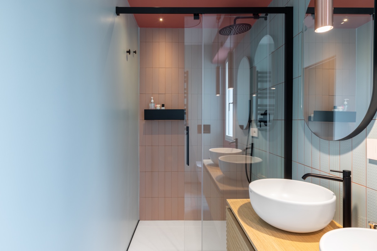Phòng tắm với bồn rửa đôi thoải mái, trần nhà màu đỏ tương phản với tường màu xanh lam.