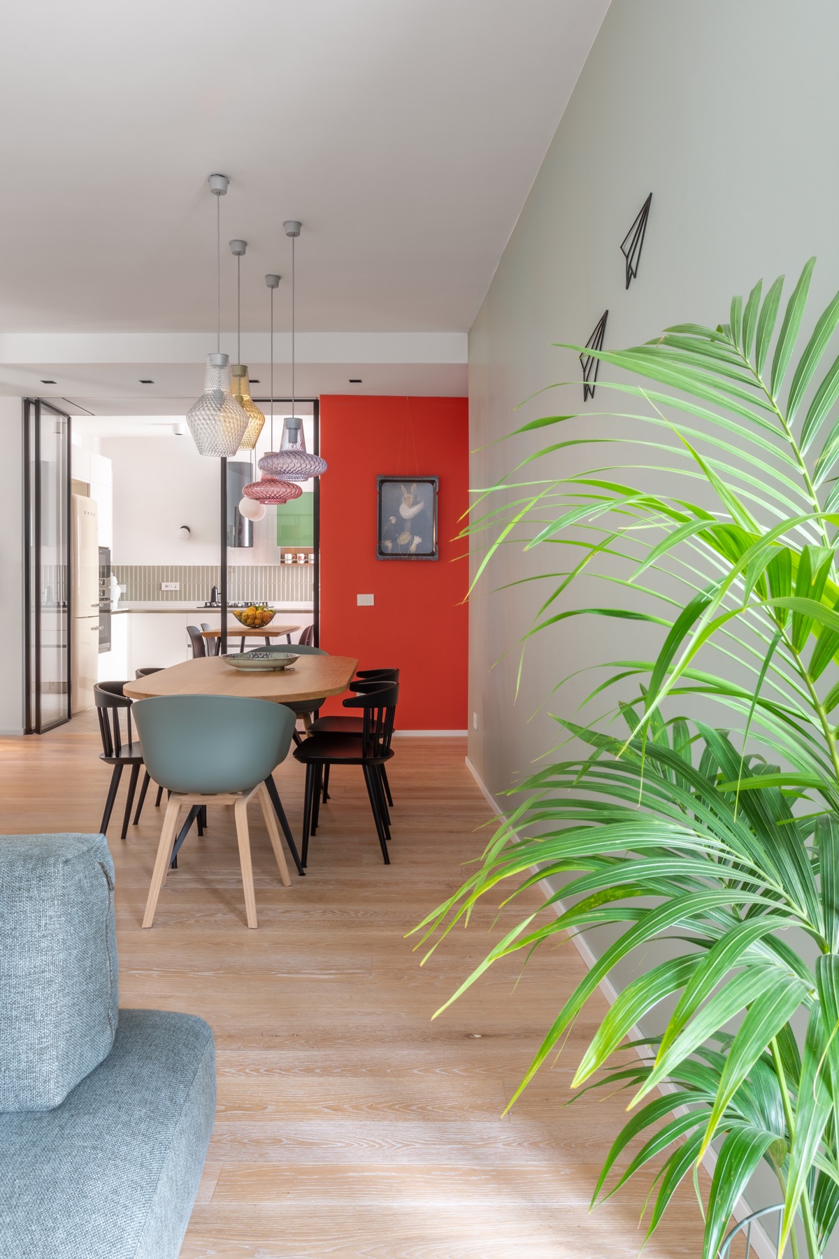 Một bức tường nhấn màu xanh lá giúp phân biệt khu vực ăn uống với không gian phòng khách được thiết kế theo phong cách mở liên thông.