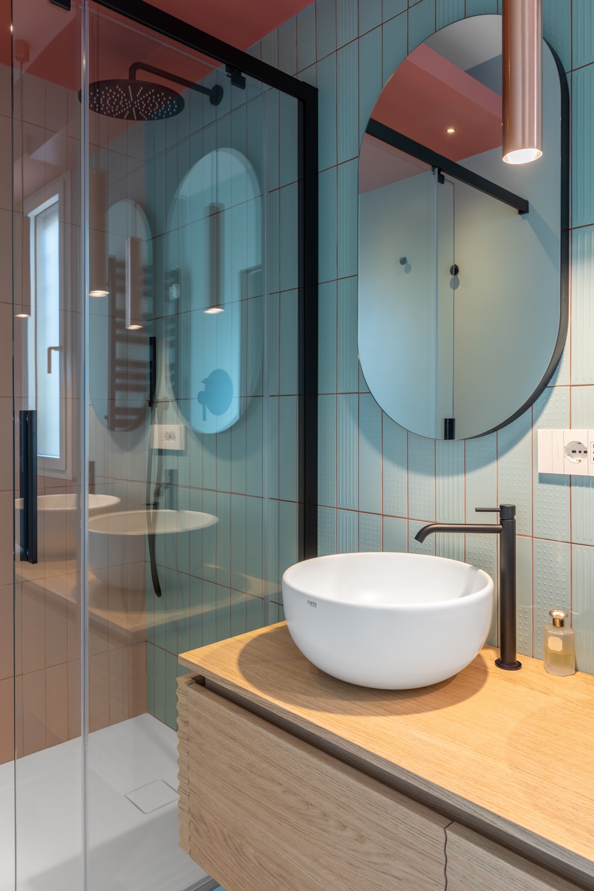 Bệ bồn rửa làm bằng gỗ sồi màu sáng tạo cảm giác thân thiện, gần gũi cho không gian phòng tắm, kết hợp hài hòa cùng hệ khung viền màu đen bắt mắt.