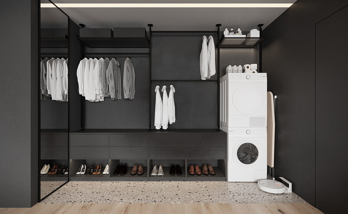 Khu vực giặt là được thiết kế tích hợp trong hệ tủ quần áo, nổi bật với sắc trắng tinh khôi trên nền đen tuyền tạo chiều sâu cho không gian.