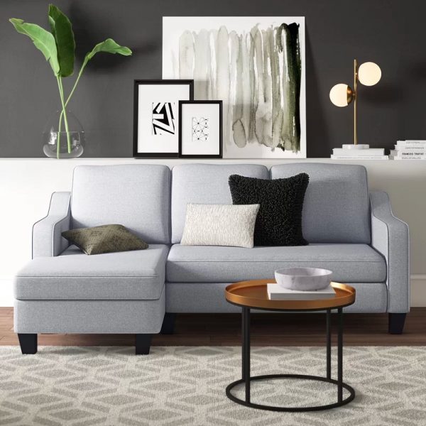Phòng khách nhỏ đẹp như "bước" ra từ tạp chí nội thất với ghế sofa màu xám sắc nét, bàn cà phê kim loại dáng tròn mềm mại đặt trên thảm trải trung tính, họa tiết hình học.