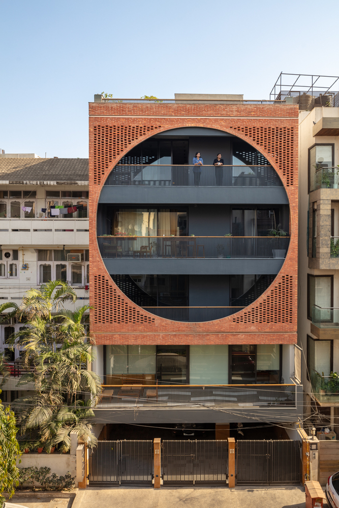 Mặt tiền nhà phố Ấn Độ cực hút mắt bởi cấu trúc hình tròn lớn bao trọn 3 tầng nhà phía trên. Xung quanh hình tròn là lớp gạch đất nung ấm áp.