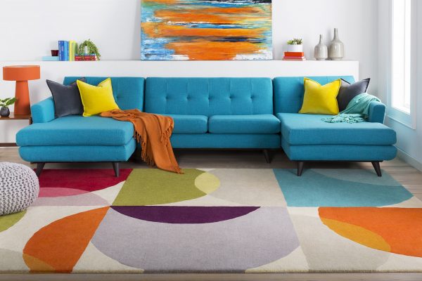 Thảm trải sàn phòng khách rực rỡ sắc màu, được làm từ len nguyên chất, nâng niu mỗi bước chân đi. Họa tiết hình học phối kết ngẫu hứng tạo bầu không khí tươi vui.