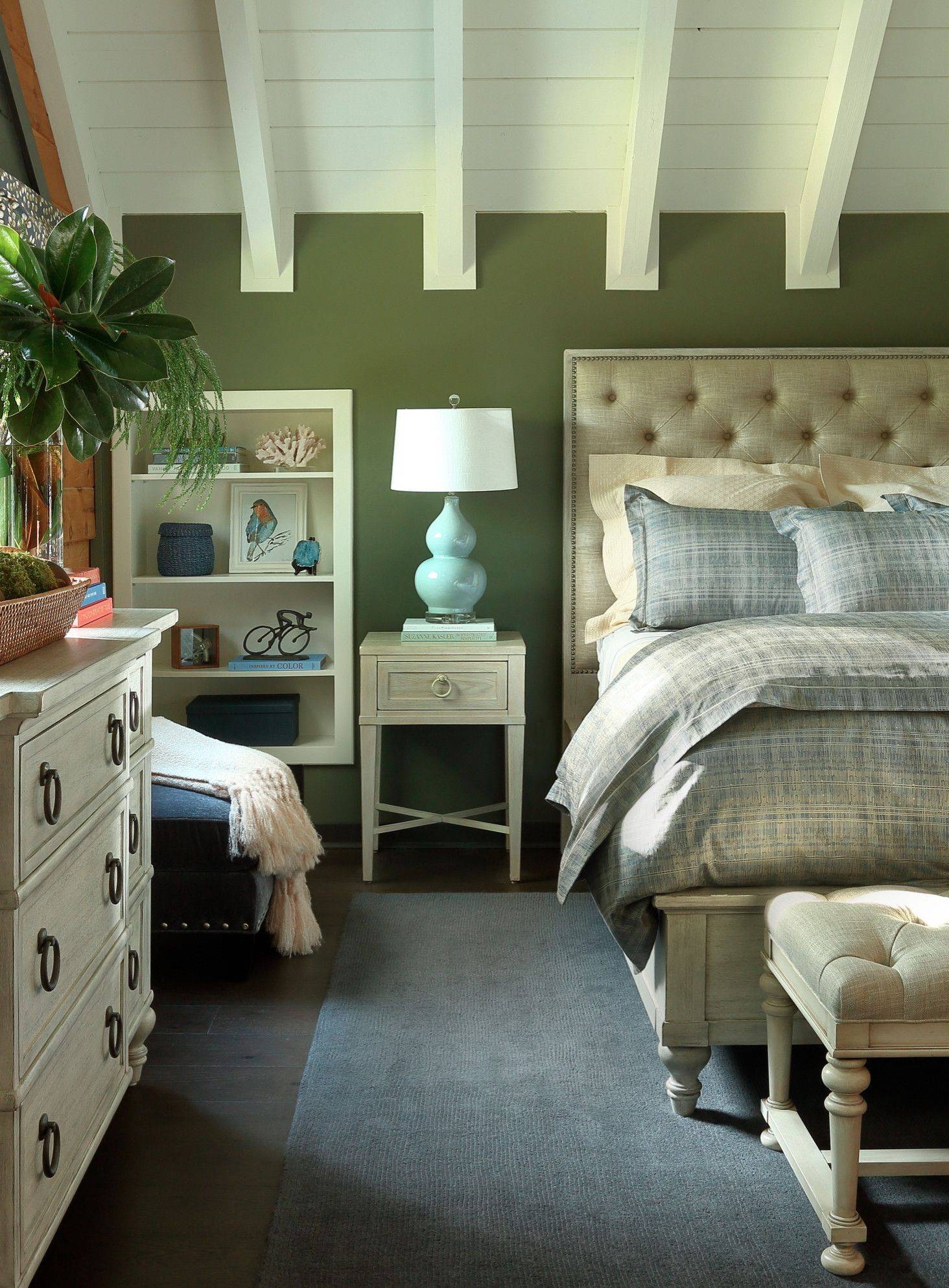 Phòng ngủ mộc mạc với trần nhà hình vòm cao thoáng và bức tường màu xanh lá làm nền cho nội thất màu trắng trở nên nổi bật hơn.