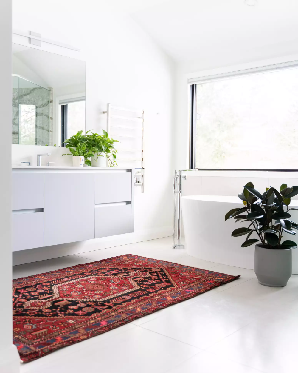 Phòng tắm rộng rãi màu trắng với thảm đỏ và cây cối
