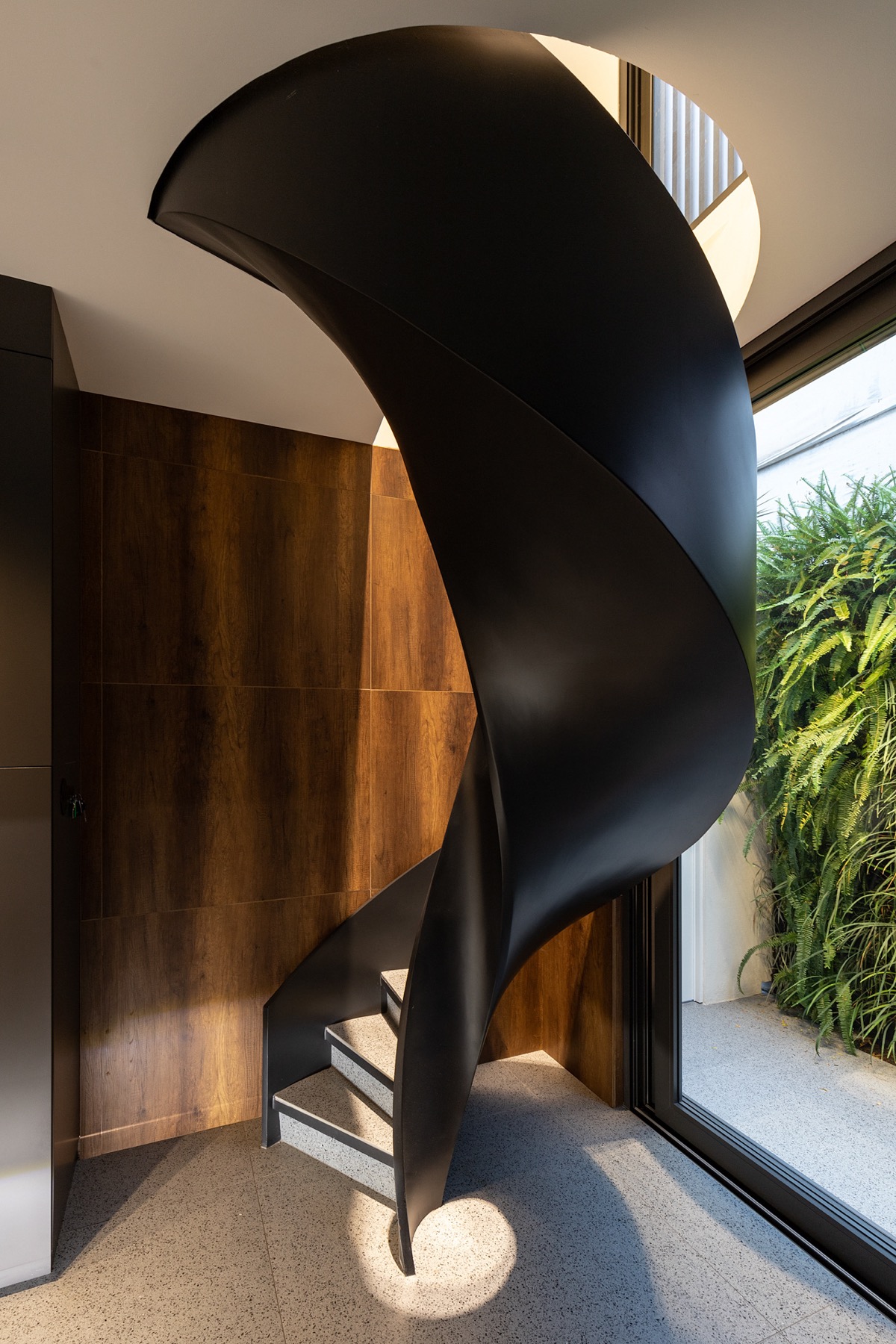 Với lớp hoàn thiện màu đen tuyền óng ả, cầu thang xoắn ốc càng thêm nổi bật.