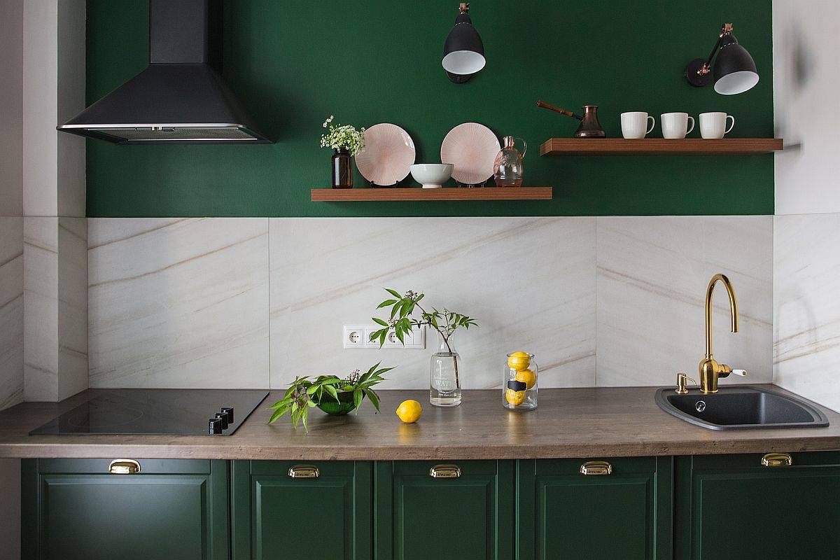 Màu xanh lá cây đậm tinh tế được kết hợp với màu be nhạt trong căn bếp nhỏ phong cách hiện đại, thông qua màu tường chắn và cửa tủ bếp dưới.