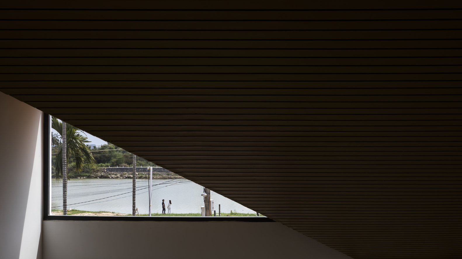 Phần mái độc đáo với mảng kính tam giác thu trọn tầm nhìn ra dòng sông phía trước nhà.