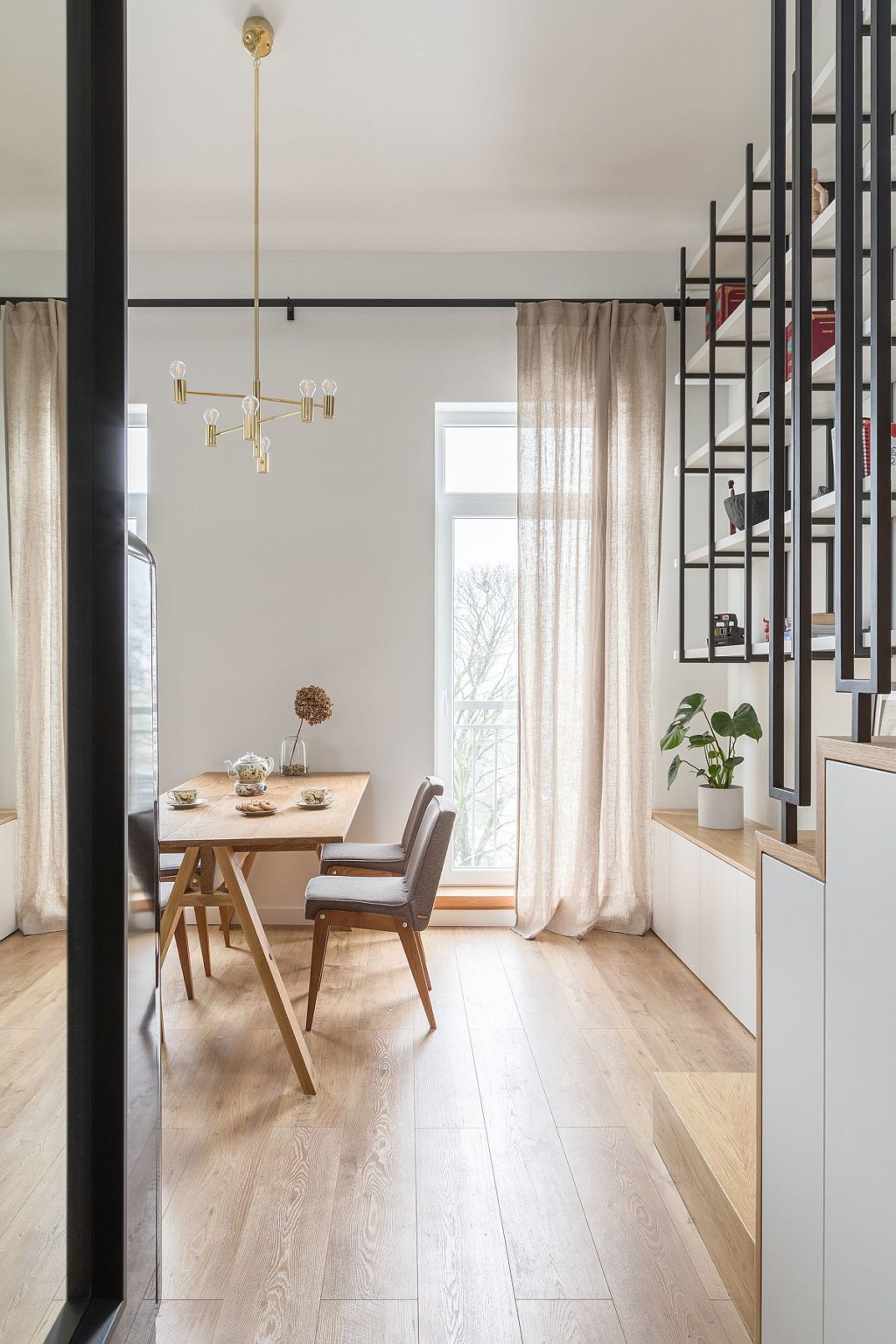 Những bức tường trắng cùng với sàn gỗ và điểm nhấn bằng kim loại tạo nên không gian sống hiện đại, ấm áp trong căn hộ nhỏ.