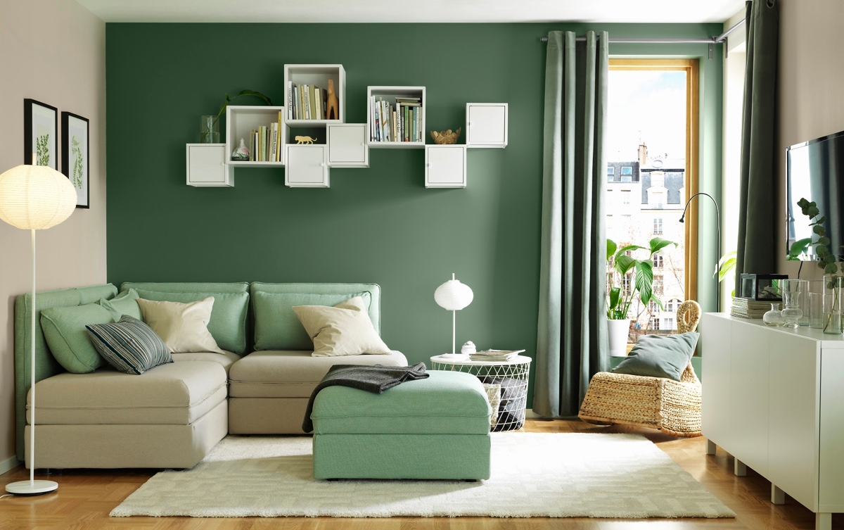 Mẫu thiết kế phòng khách đơn giản mà đẹp với sự tương phản thú vị giữa thảm trải sàn màu trắng và bức tường xanh lá, đệm đi văng màu bạc hà. Đây là nơi hoàn hảo để bạn đọc sách hoặc xem các chương trình truyền hình yêu thích.