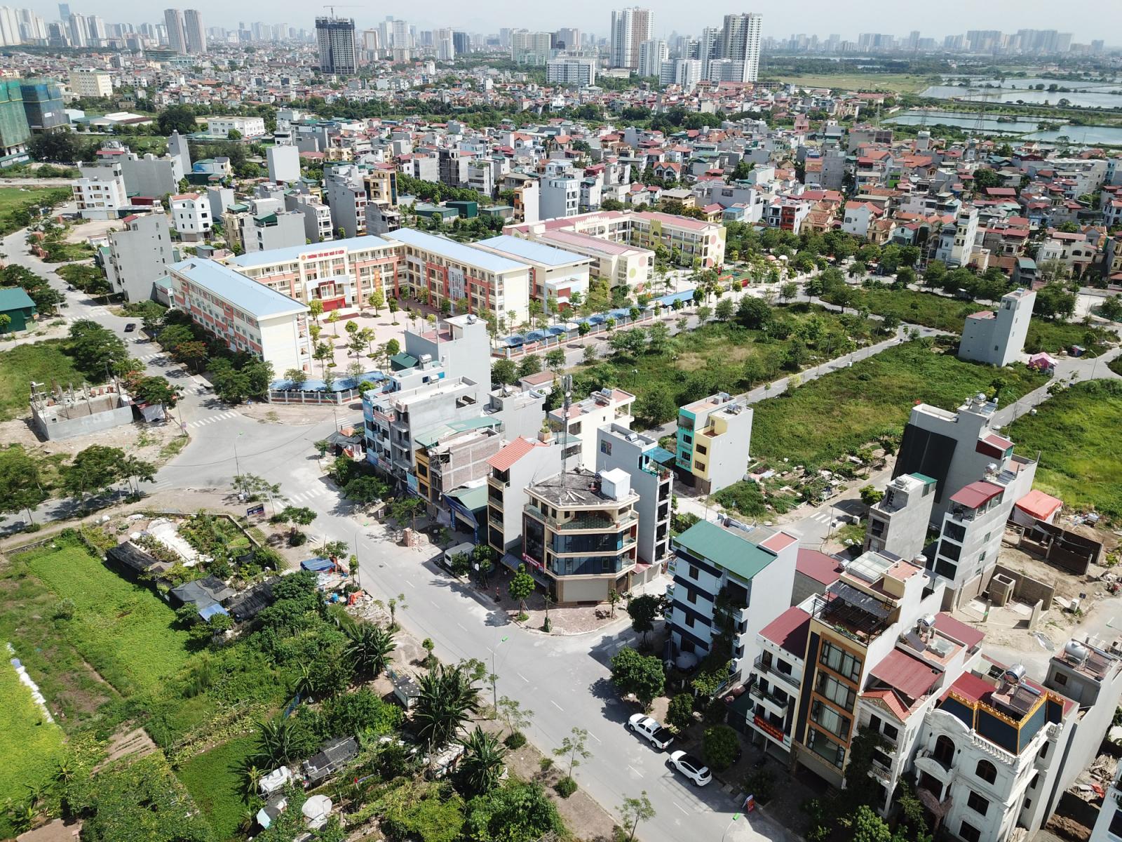 hình ảnh một góc thành phố nhìn từ trên cao với nhà cao tầng, thấp tầng, cây xanh, đất xen kẹt
