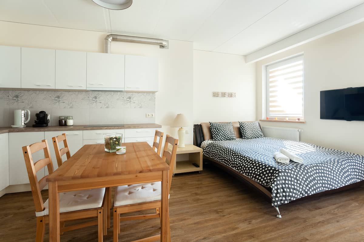 bộ bàn ăn bằng gỗ đặt cạnh giường ngủ trong căn hộ mini