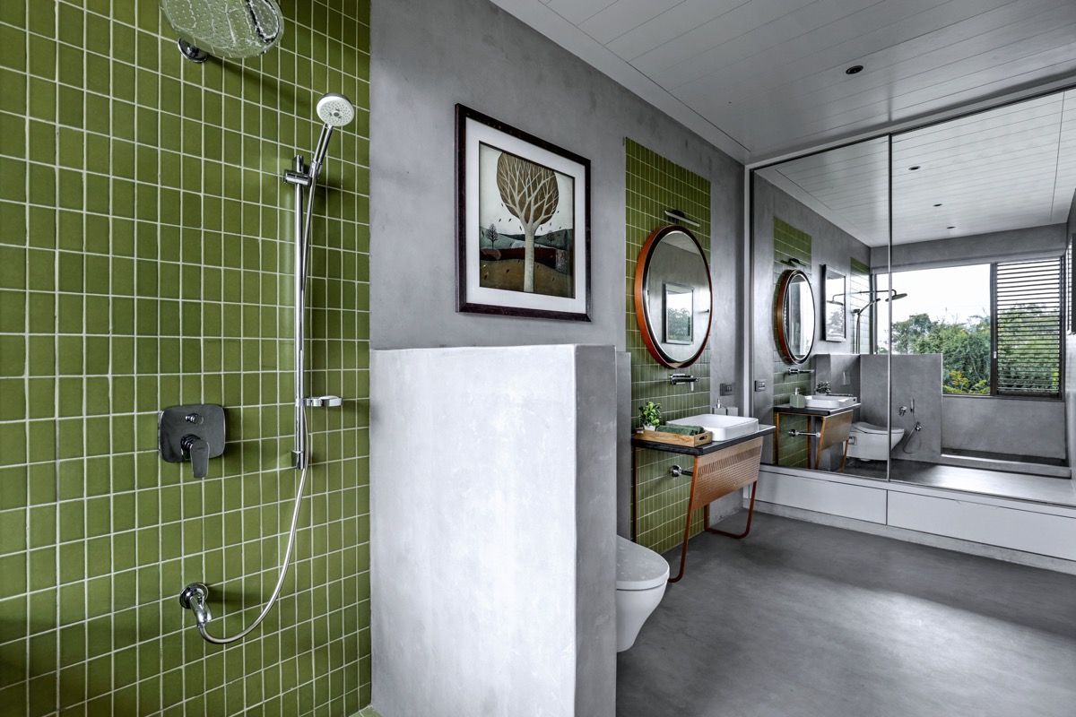 Phòng tắm cũng được trang trí với các điểm nhấn màu xanh lá cây bổ sung cho bảng màu xám trung tính có phần thô lạnh.