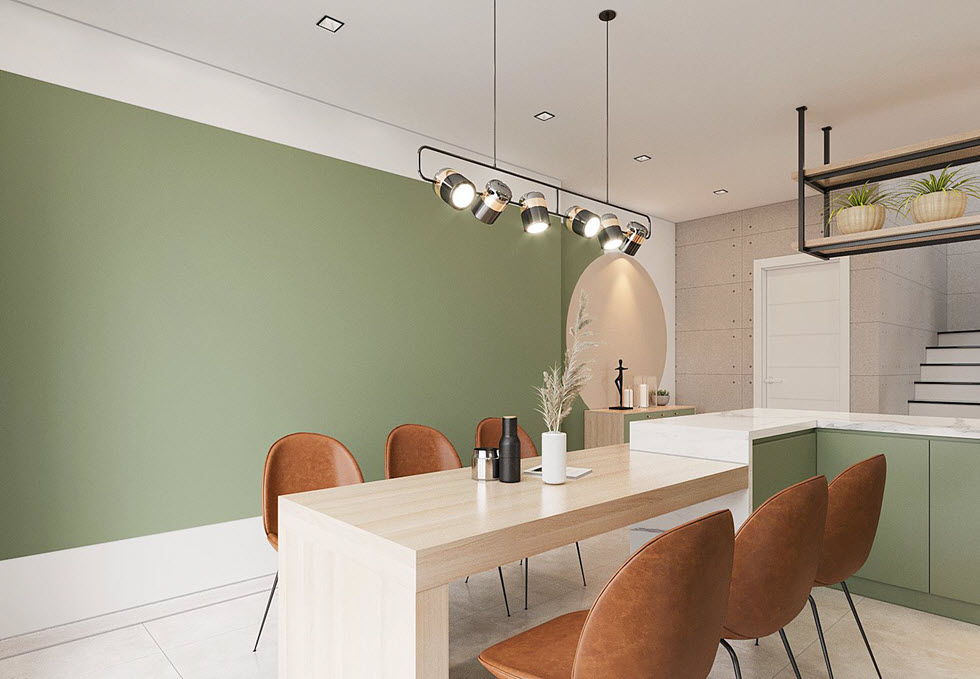 Tường và tủ bếp sơn màu xanh lá cây tương phản nhẹ nhàng với sắc trắng của trần, sàn và ghế ăn màu nâu đất. Sự hòa quyện của những màu sắc này tạo cảm giác ấm cúng, hiện đại.
