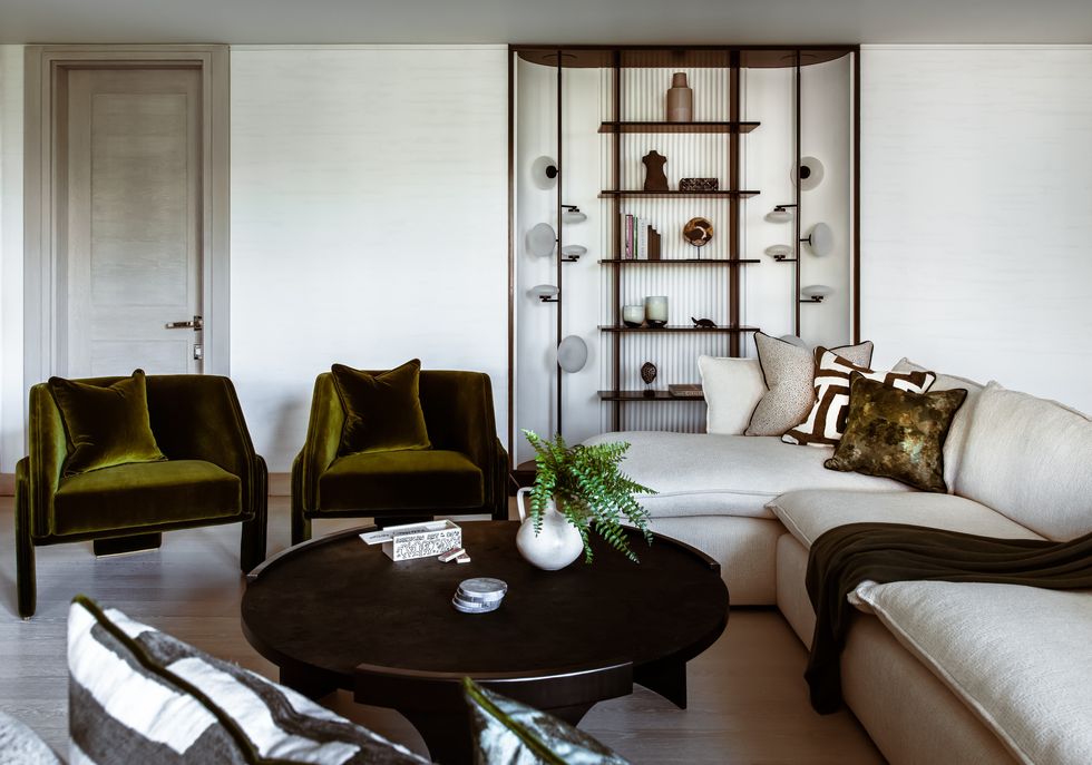 Bộ đôi ghế nhung màu xanh ô liu là điểm nhấn màu sắc sinh động, tràn đầy năng lượng trong không gian phòng khách này.