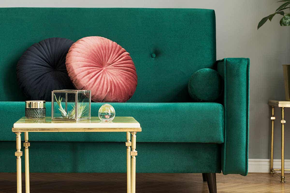 Ghế sofa nhung màu xanh mòng két, gối tròn màu hồng mận và tím than