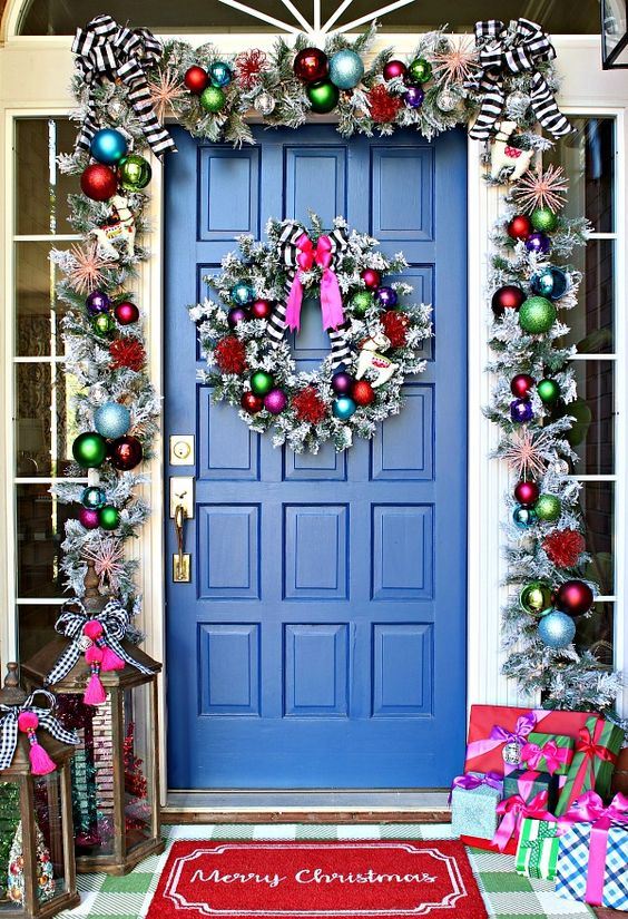 Trang trí cửa trước chào đón Giáng sinh với một vòng hoa bạc và đồ trang trí Noel đầy màu sắc. Ý tưởng này tuy không mới nhưng vẫn luôn hiệu quả.