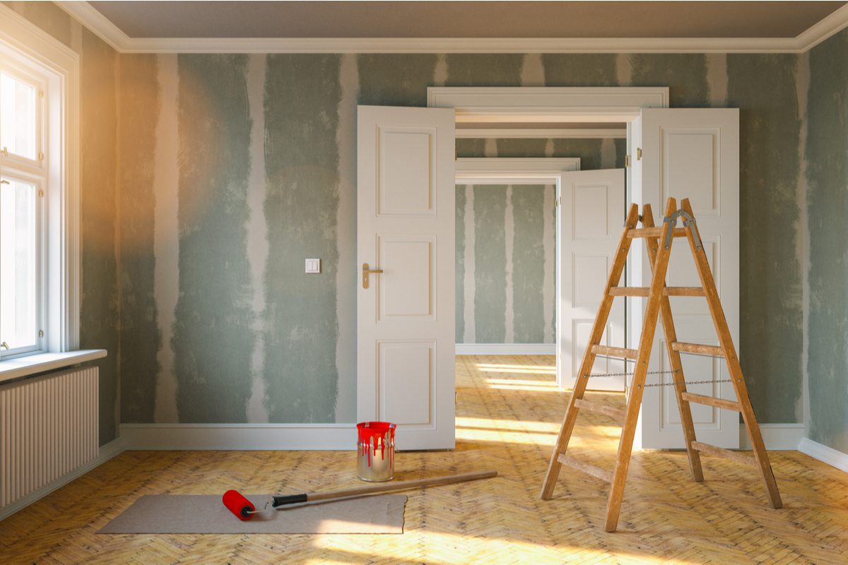 hình ảnh căn phòng đang sửa sang dở dang, thang gỗ, sơn tường loang lổ