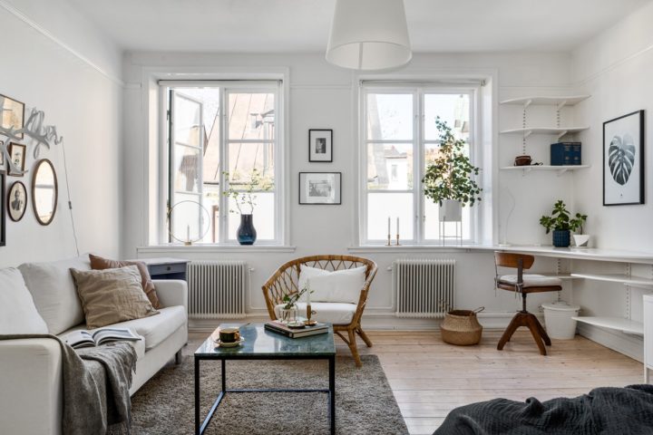 Mẫu phòng khách nhỏ hiện đại tối giản tích hợp góc làm việc tại nhà gọn đẹp. Hai khung cửa sổ kính cao rộng mang đến ánh sáng tự nhiên ngập tràn, tạo cảm giác thoáng rộng hơn.