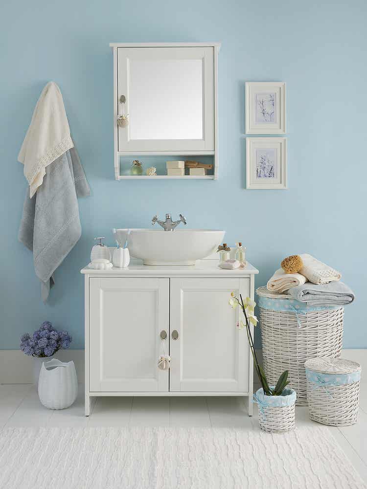 Phòng tắm nhỏ với tường sơn xanh da trời, tủ tường màu trắng, tủ dưới bồn rửa màu trắng