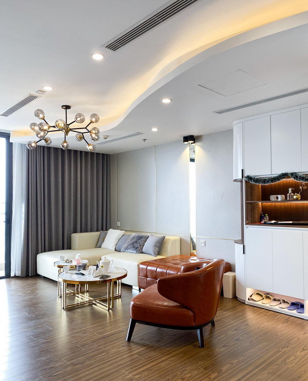 Phòng khách được thiết kế theo phong cách hiện đại sang trọng với sự tương phản thú vị giữa tông màu nâu và trắng sáng.