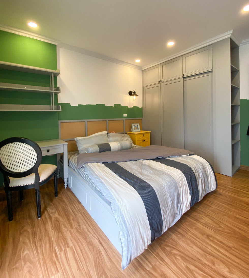 Phòng ngủ thứ hai có diện tích khiêm tốn hơn và khá lạ mắt với bảng màu xanh lá phối cùng sắc trắng xám.