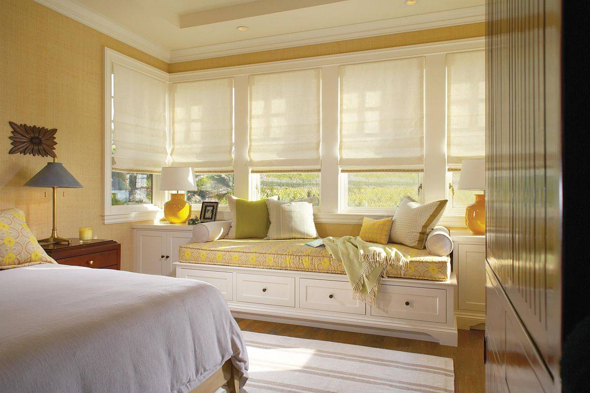 Phòng ngủ hiện đại đáng yêu với những bức tường vàng mơ cùng với ghế ngồi bên cửa sổ cùng tông màu.