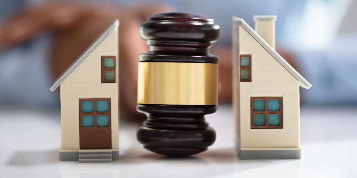 hình ảnh búa pháp luật chia đôi mô hình ngôi nhà minh họa cho việc phân chia nhà, đất khi ly hôn
