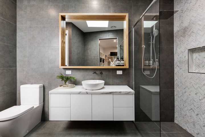 Gương lớn gắn tường giúp hút sáng tự nhiên và tạo cảm giác rộng thoáng hơn cho phòng tắm, vệ sinh nhà lô 6,5 tầng.