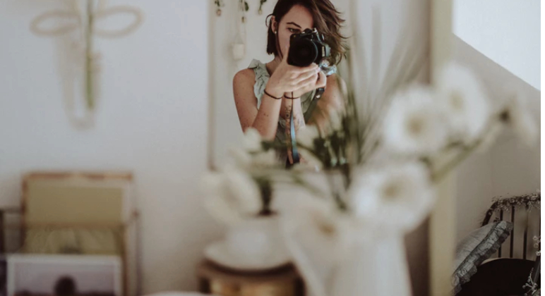 hình ảnh cô gái cầm máy ảnh cơ chuẩn bị chụp ảnh trong nhà 