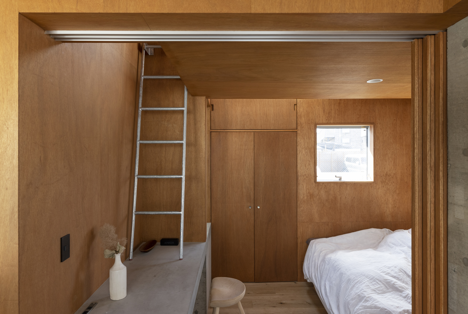 Toàn bộ tường và trần phòng ngủ được ốp gỗ tự nhiên tông màu ấm áp, thân thiện.