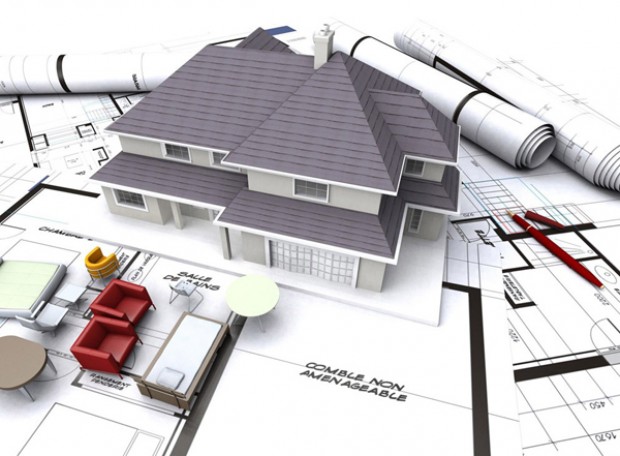 hình ảnh mô hình ngôi nhà đặt trên bản vẽ thiết kế xây dựng minh họa cho việc xin giấy phép xây dựng
