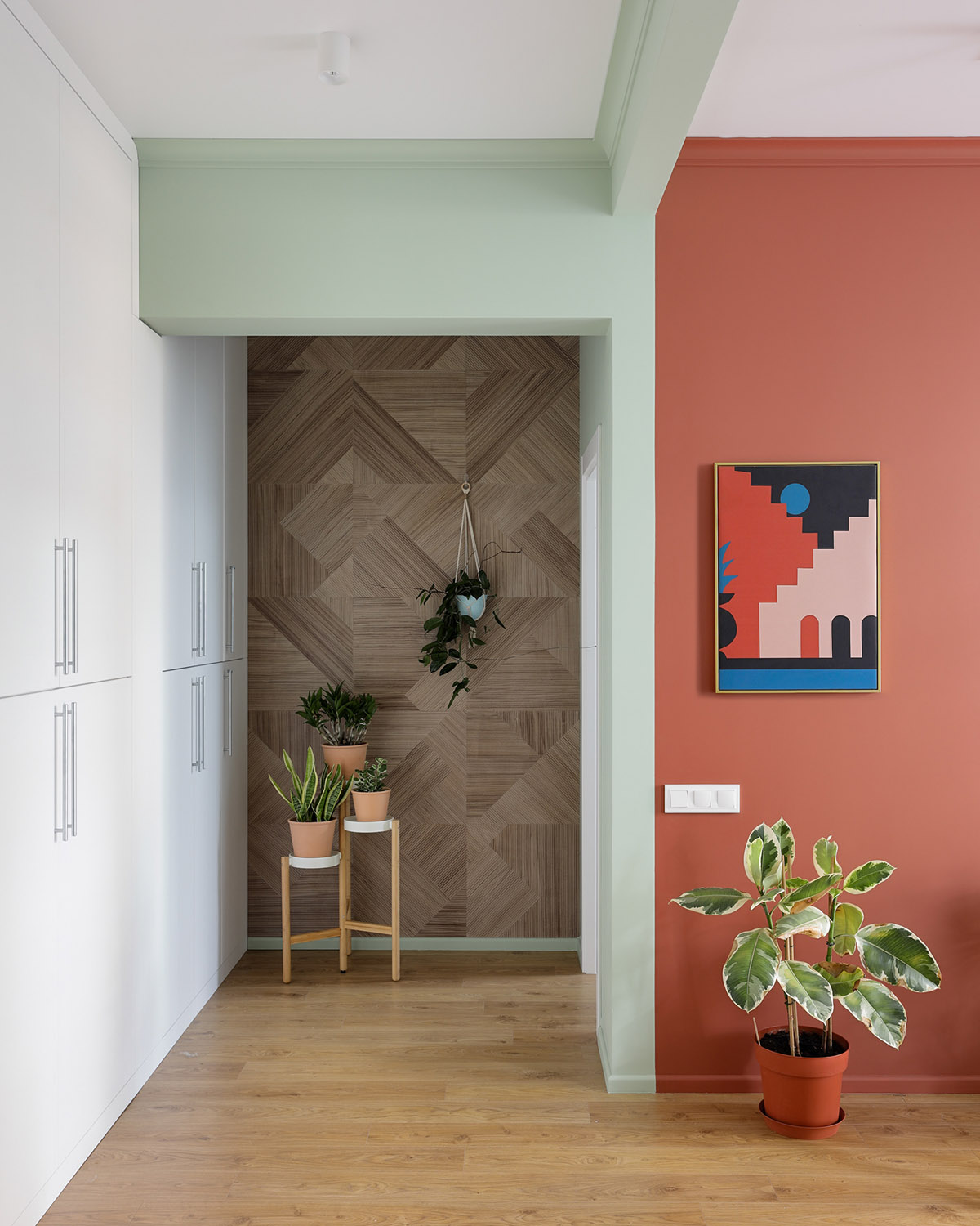 Ở cuối hành lang, một bức tường gỗ thân thiện, làm cho một phông nền phù hợp cho một loạt các chậu cây trồng trong nhà.