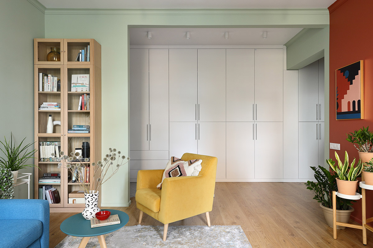 Hành lang căn hộ - nơi hiện diện tủ lưu trữ âm tường màu trắng kịch trần, tương phản với không gian sắc màu của phòng khách.