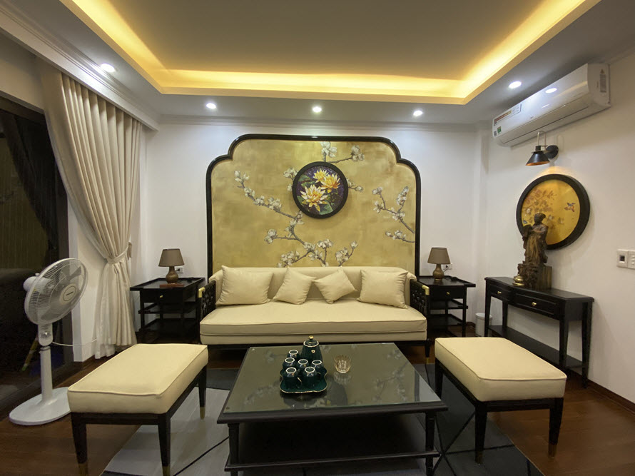 Phòng khách phong cách Đông Dương với sofa nệm trắng sữa, tranh tường ấn tượng